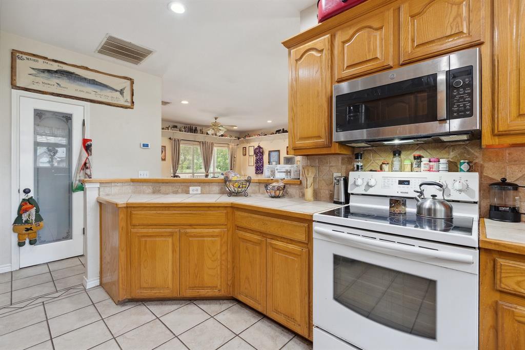 118 Cagle Quinlan, TX 75474 - Photo 5 of 23 a kitchen with stainless steel appliances a stove microwave and cabinets