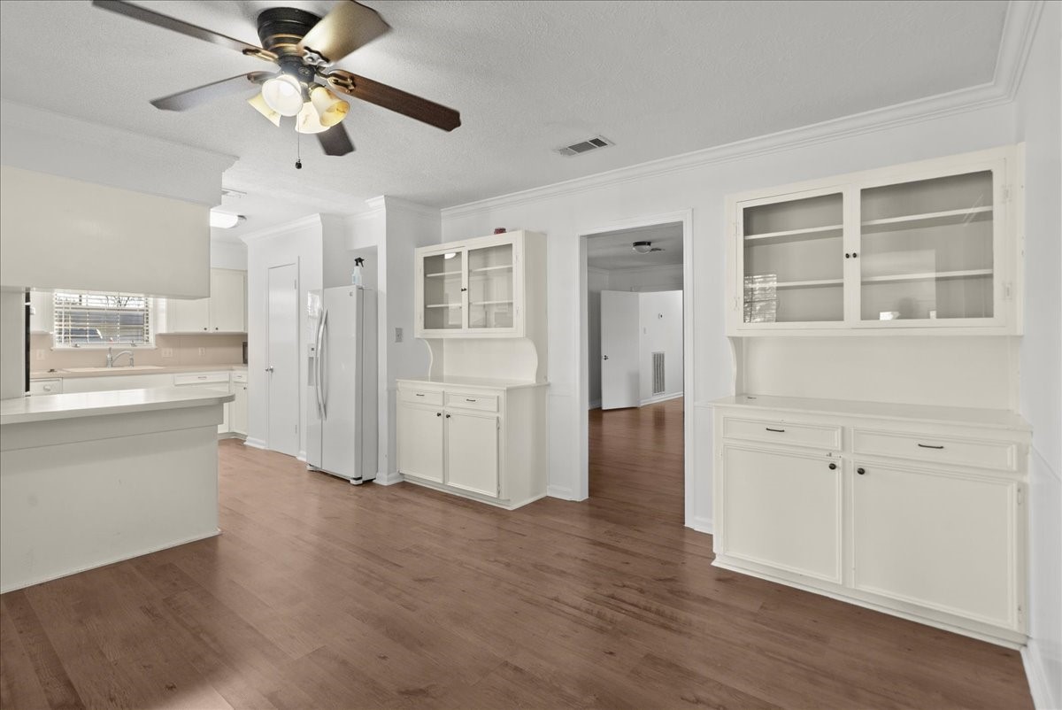 105 Alice Street Anahuac, TX 77514 - Photo 4 of 39 a view of a kitchen with wooden floor and a ceiling fan