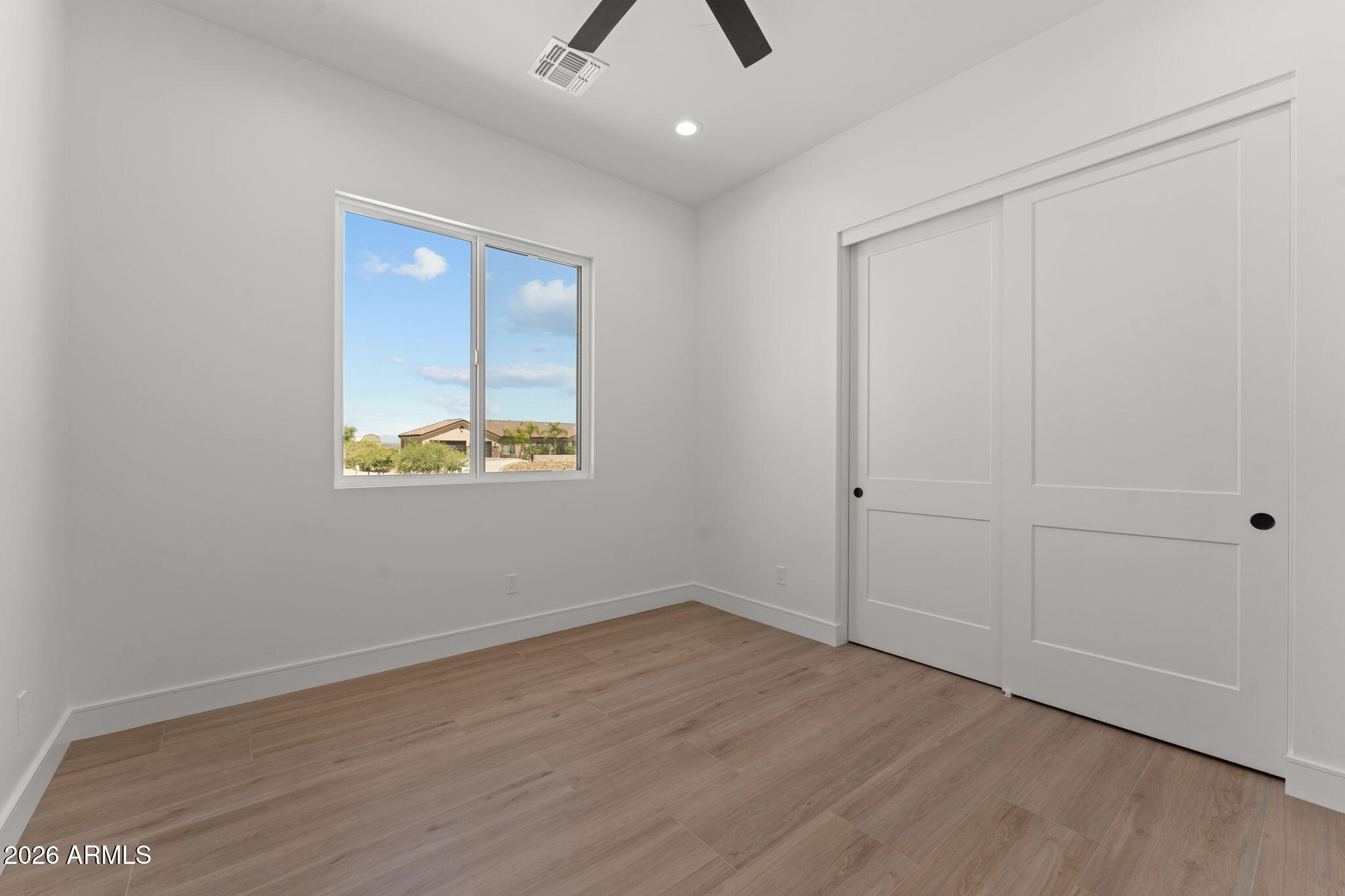 2855 Percheron Road Wickenburg, AZ 85390 - Photo 44 of 58 an empty room with wooden floor and windows