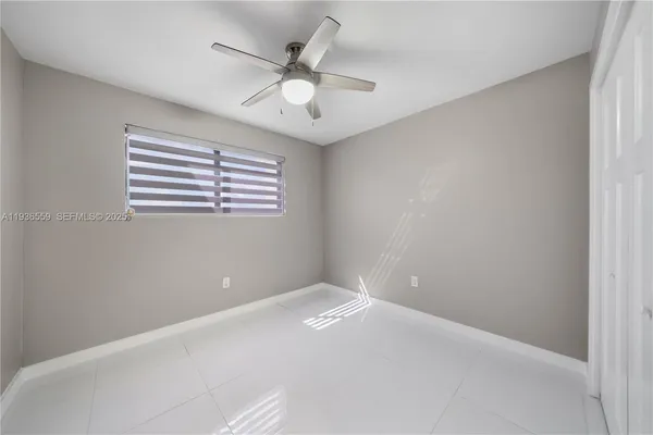 an empty room with windows and fan