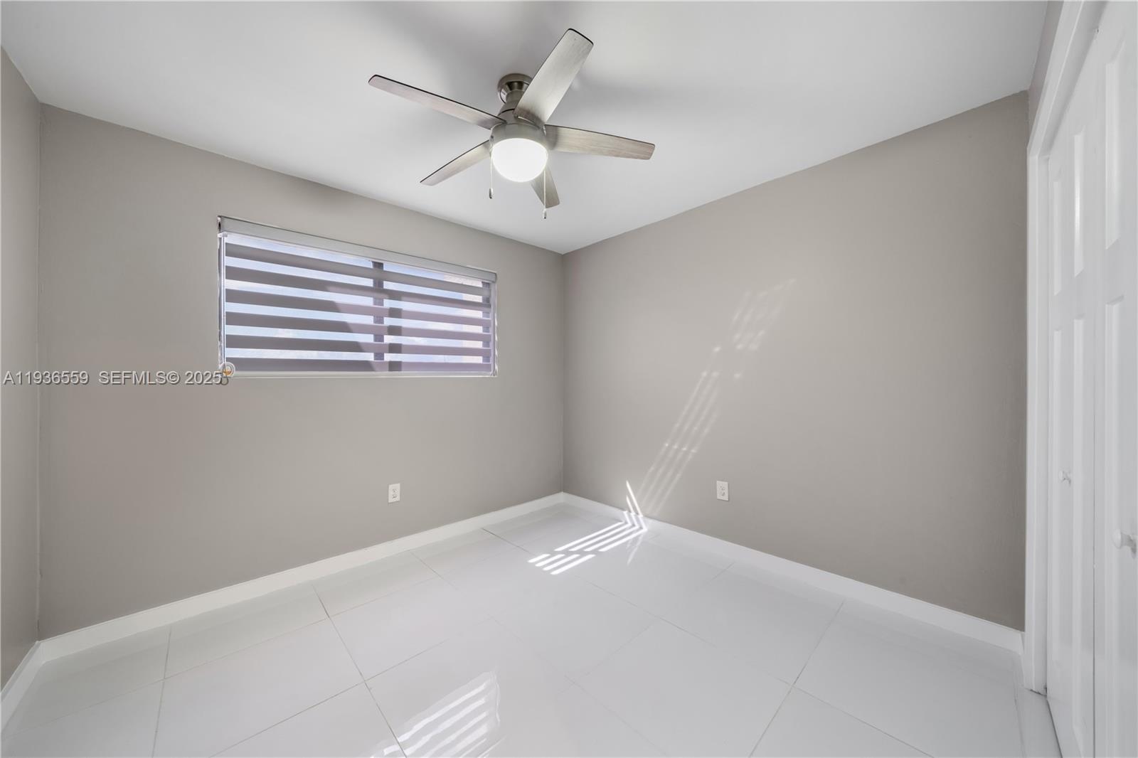 8095 Northwest 8th Street, Unit 412 Miami, FL 33126 - Photo 12 of 20 an empty room with windows and fan