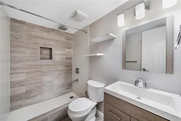 a bathroom with a sink a toilet and shower