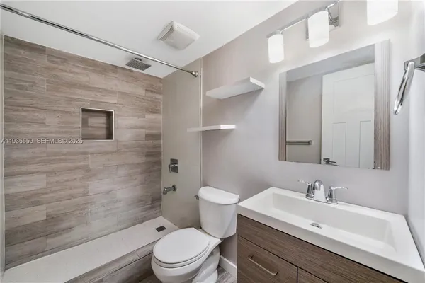 a bathroom with a sink a toilet and shower