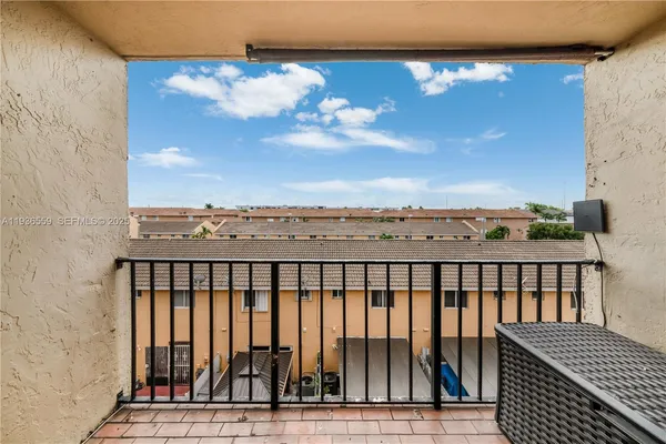 a view of a balcony with wooden floor and a yard