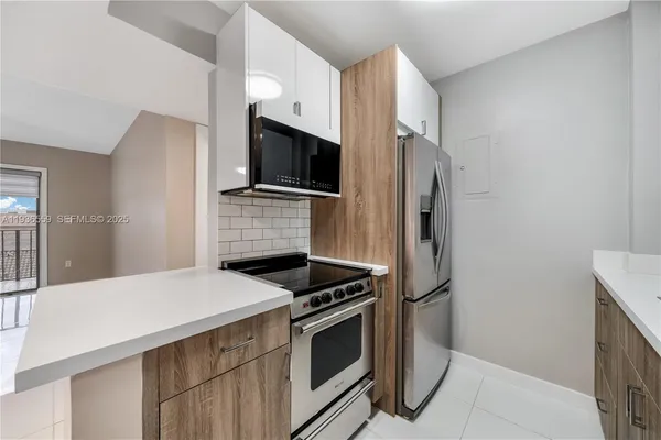 a kitchen with stainless steel appliances a stove microwave and refrigerator