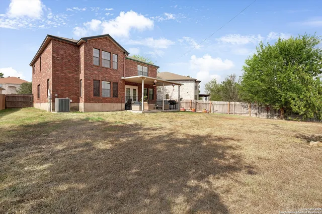 a view of a house with a big yard and large trees