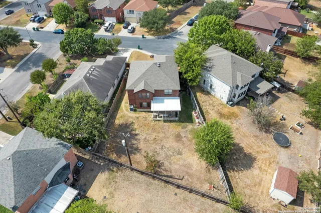 an aerial view of a house with a garden and trees