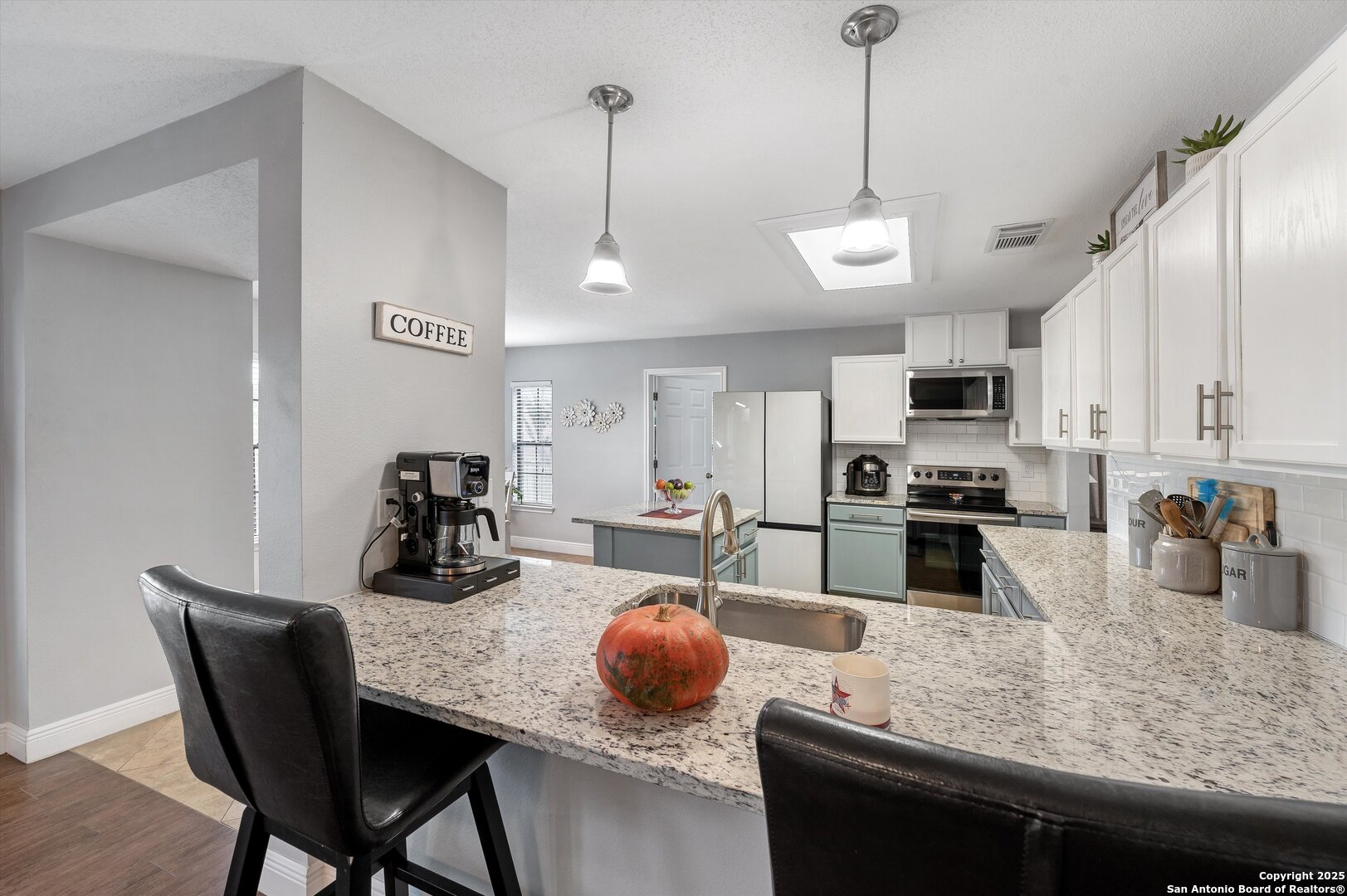 7624 Lonecrest Lane Converse, TX 78109 - Photo 10 of 32 a kitchen with stainless steel appliances granite countertop a sink a stove and chairs with wooden floor