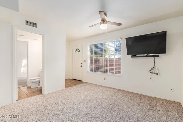 en empty room with windows and ceiling fan