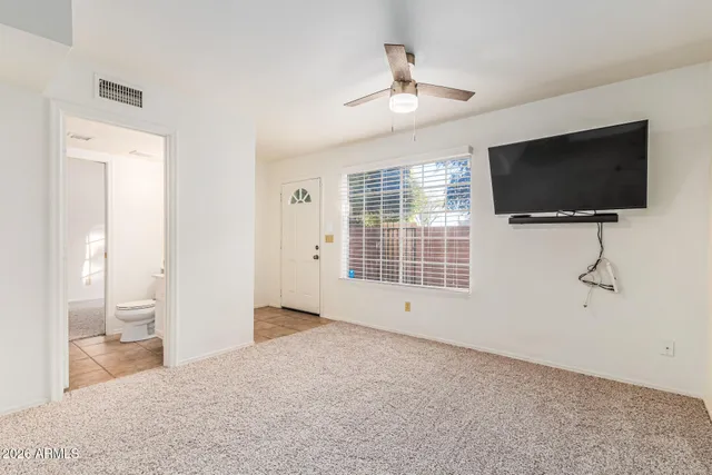 en empty room with windows and ceiling fan