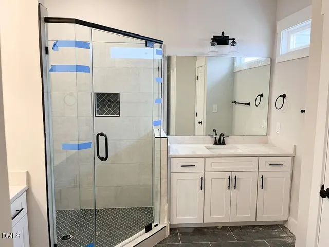a bathroom with a shower sink and mirror