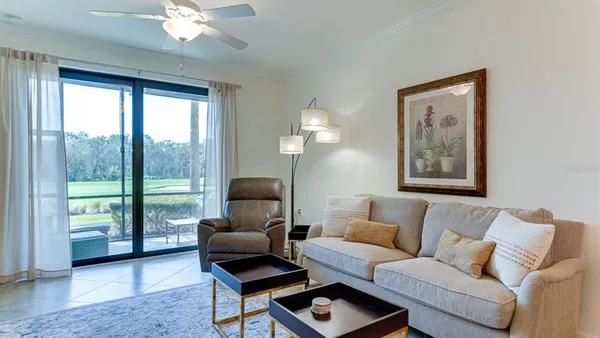 a living room with furniture and a floor to ceiling window