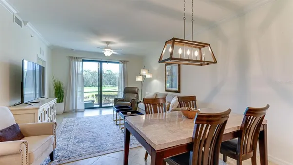 a view of a dining room with furniture a chandelier and a flat screen tv