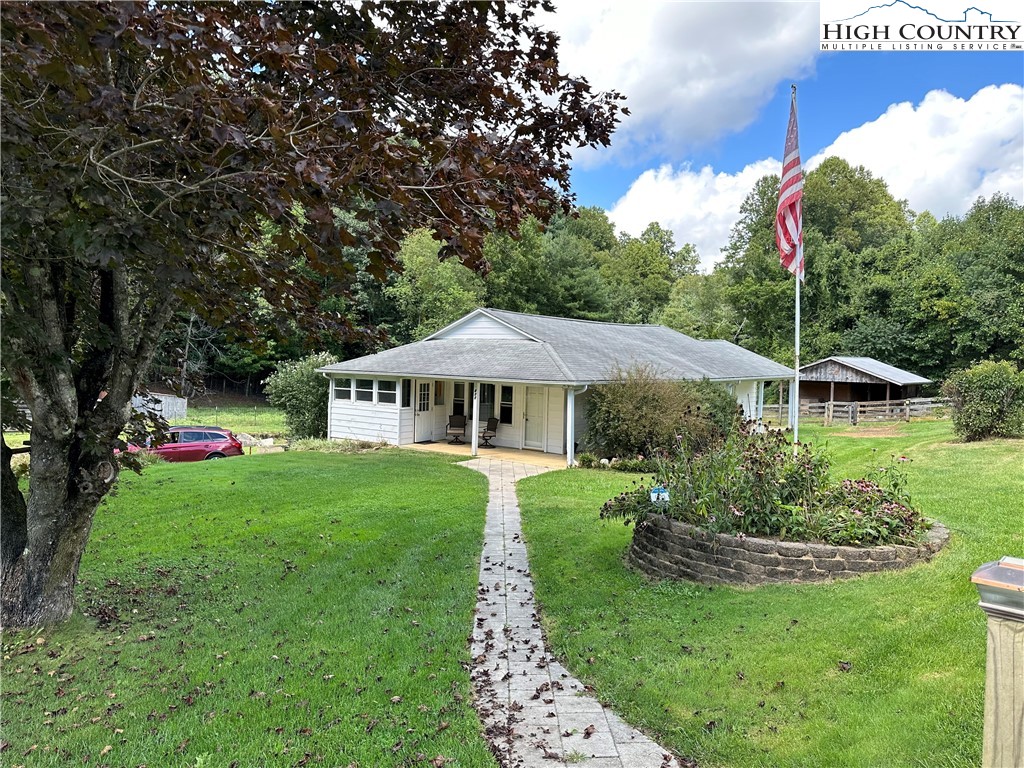 a view of a house with a yard and sitting area