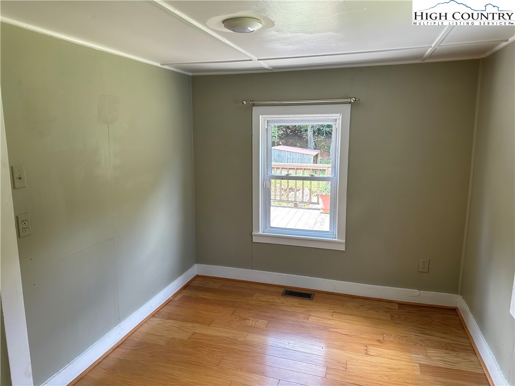 405 Wilson Road Ennice, NC 28623 - Photo 11 of 29 an empty room with wooden floor and windows
