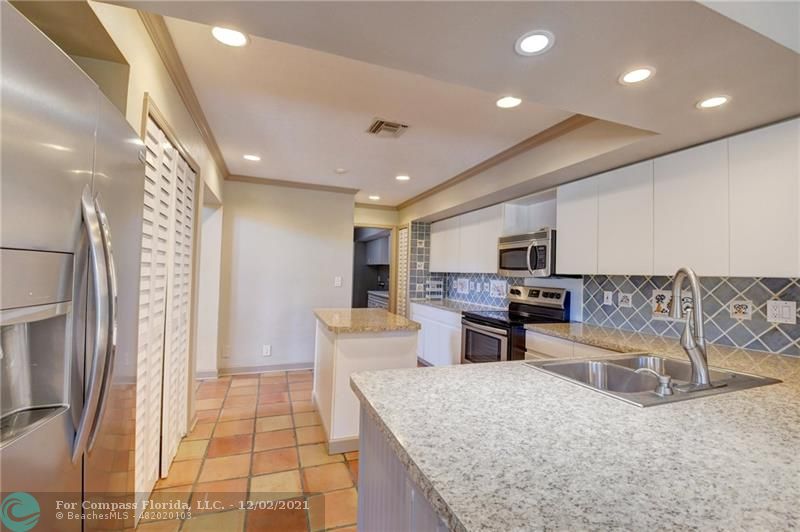 Mission Bay Boca Raton, FL 33428 - Photo 19 of 33 a large living room with stainless steel appliances furniture a rug and a view of kitchen