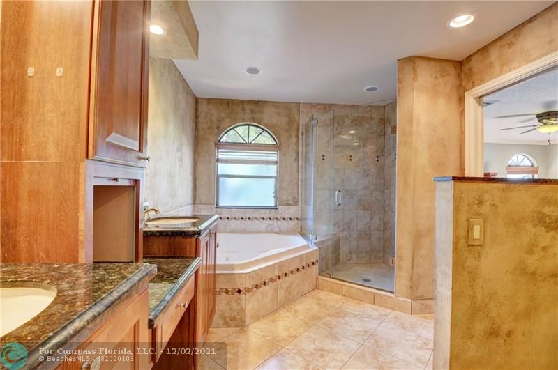 Mission Bay Boca Raton, FL 33428 - Photo 29 of 33 a bathroom with a tub a sink and a large mirror