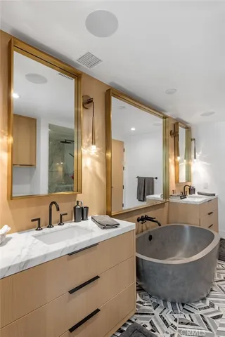 a bathroom with a granite countertop sink and a large mirror