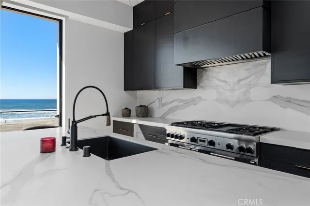 a kitchen with stainless steel appliances kitchen island a stove and a sink