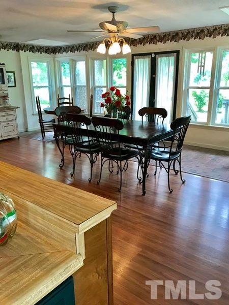 2685 Ridgeville Road Prospect Hill, NC 27314 - Photo 20 of 25 a dining room with wooden floor a chandelier a glass table and chairs