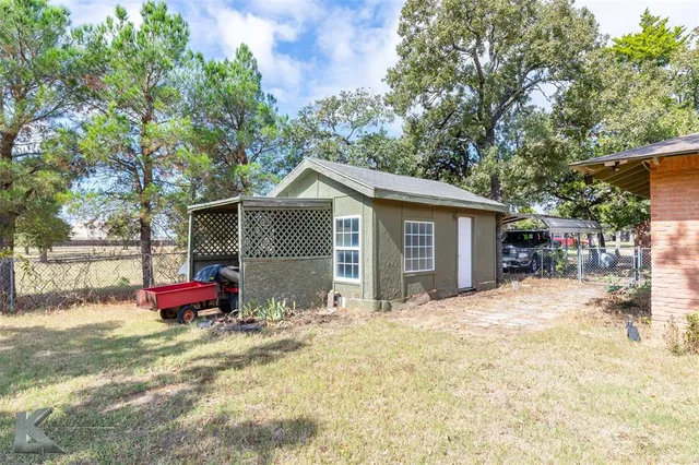 a view of a house with a backyard and a tree