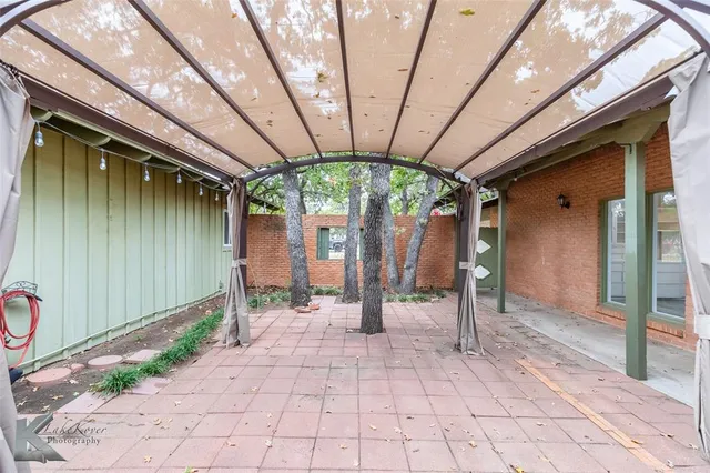 a view of a porch with a table and chairs and floor to ceiling window