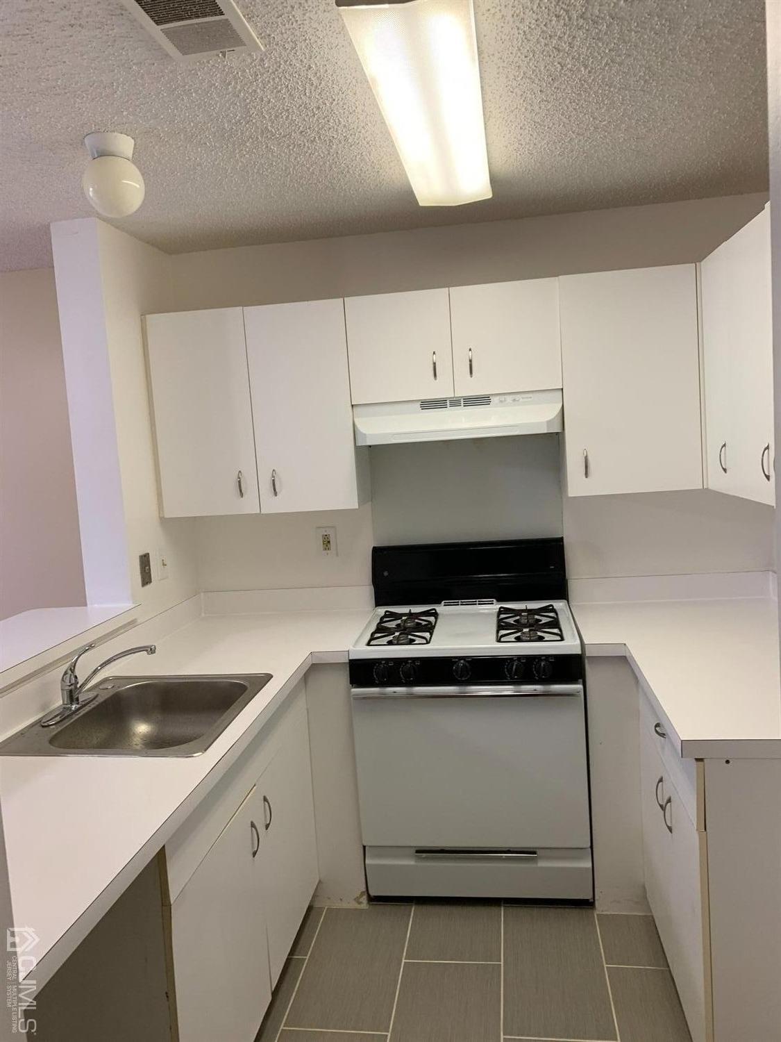 1226 Edpas Road New Brunswick, NJ 08901 - Photo 3 of 18 a kitchen with cabinets appliances a sink and a stove