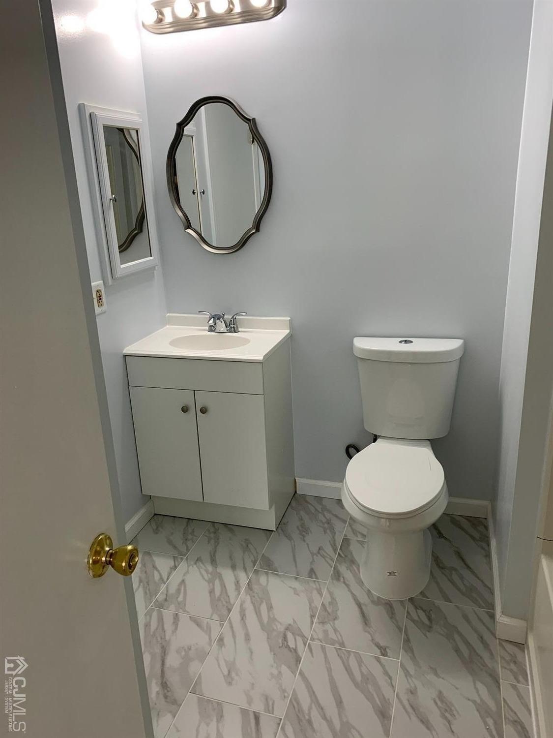 1226 Edpas Road New Brunswick, NJ 08901 - Photo 6 of 18 a bathroom with a toilet a sink and a mirror