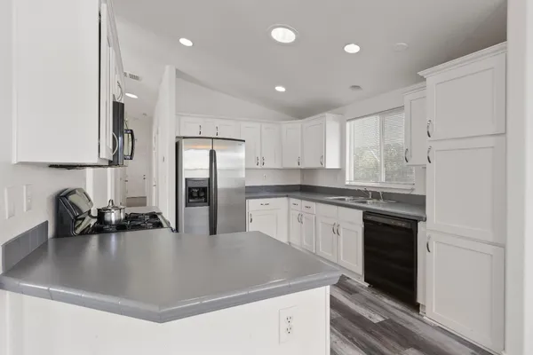 a kitchen with kitchen island a sink stainless steel appliances and cabinets