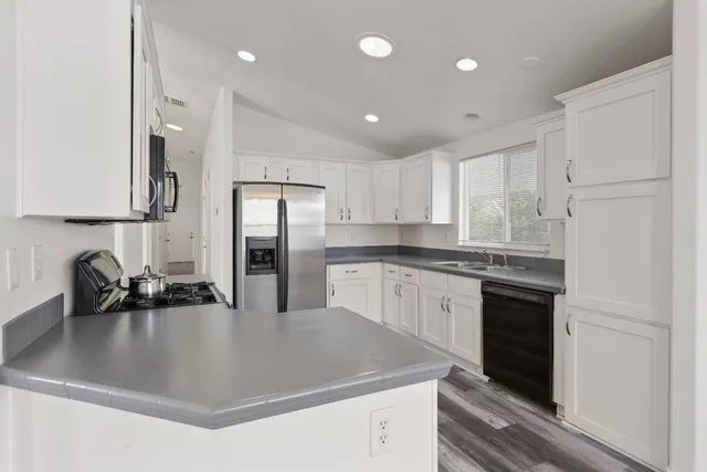 a kitchen with kitchen island a sink stainless steel appliances and cabinets
