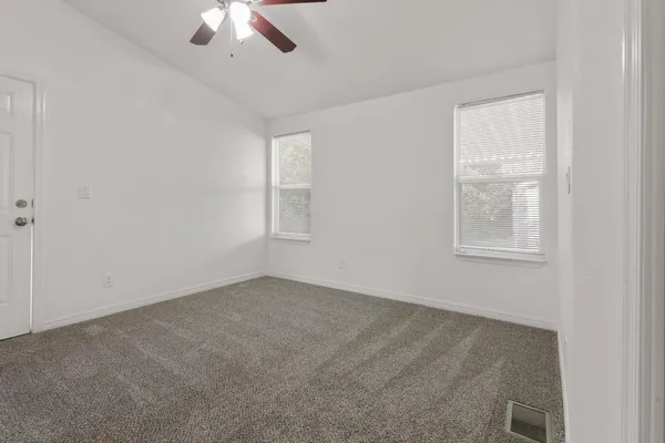 an empty room with a window and a ceiling fan