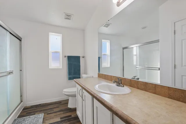 a bathroom with a sink a toilet and shower