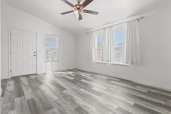 a view of an empty room with a window and closet area