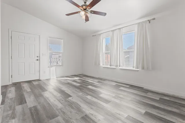 a view of an empty room with a window and closet area