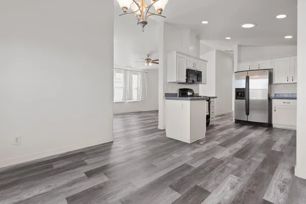 a kitchen with a refrigerator and a stove top oven
