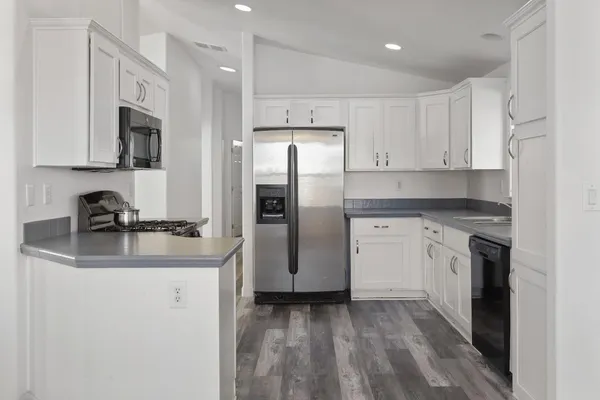 a kitchen with stainless steel appliances granite countertop a refrigerator sink and stove