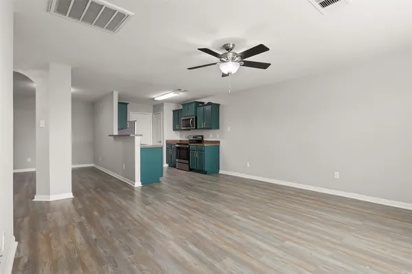 a view of a kitchen with wooden floor a sink and dishwasher