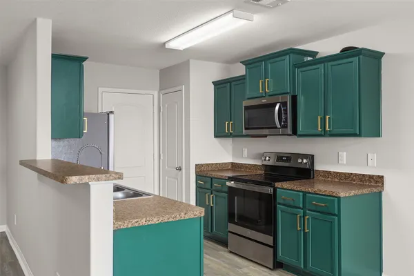 a kitchen with granite countertop cabinets appliances and a sink