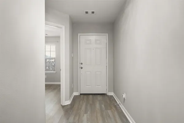 a view of a hallway with wooden floor