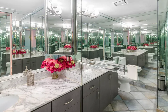 a bathroom with a granite countertop sink a large mirror and a shower