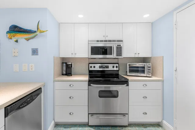 a kitchen with stainless steel appliances granite countertop a sink a stove and a refrigerator