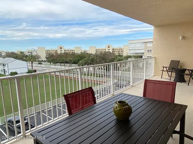 a view of a terrace with furniture and a floor to ceiling window