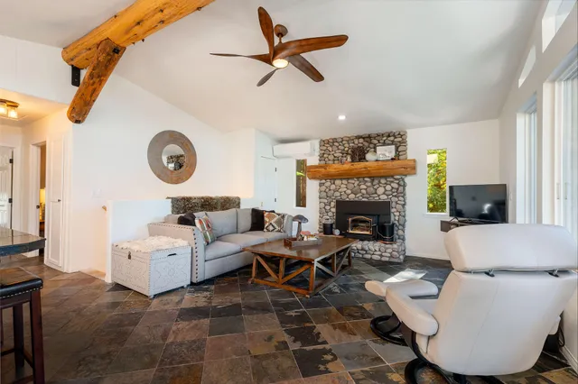 a living room with furniture kitchen view and a large window