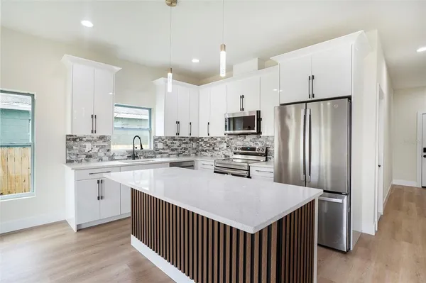 a kitchen with refrigerator cabinets and wooden floor