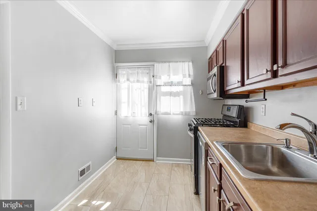 a kitchen that has a sink cabinets counter space and a window