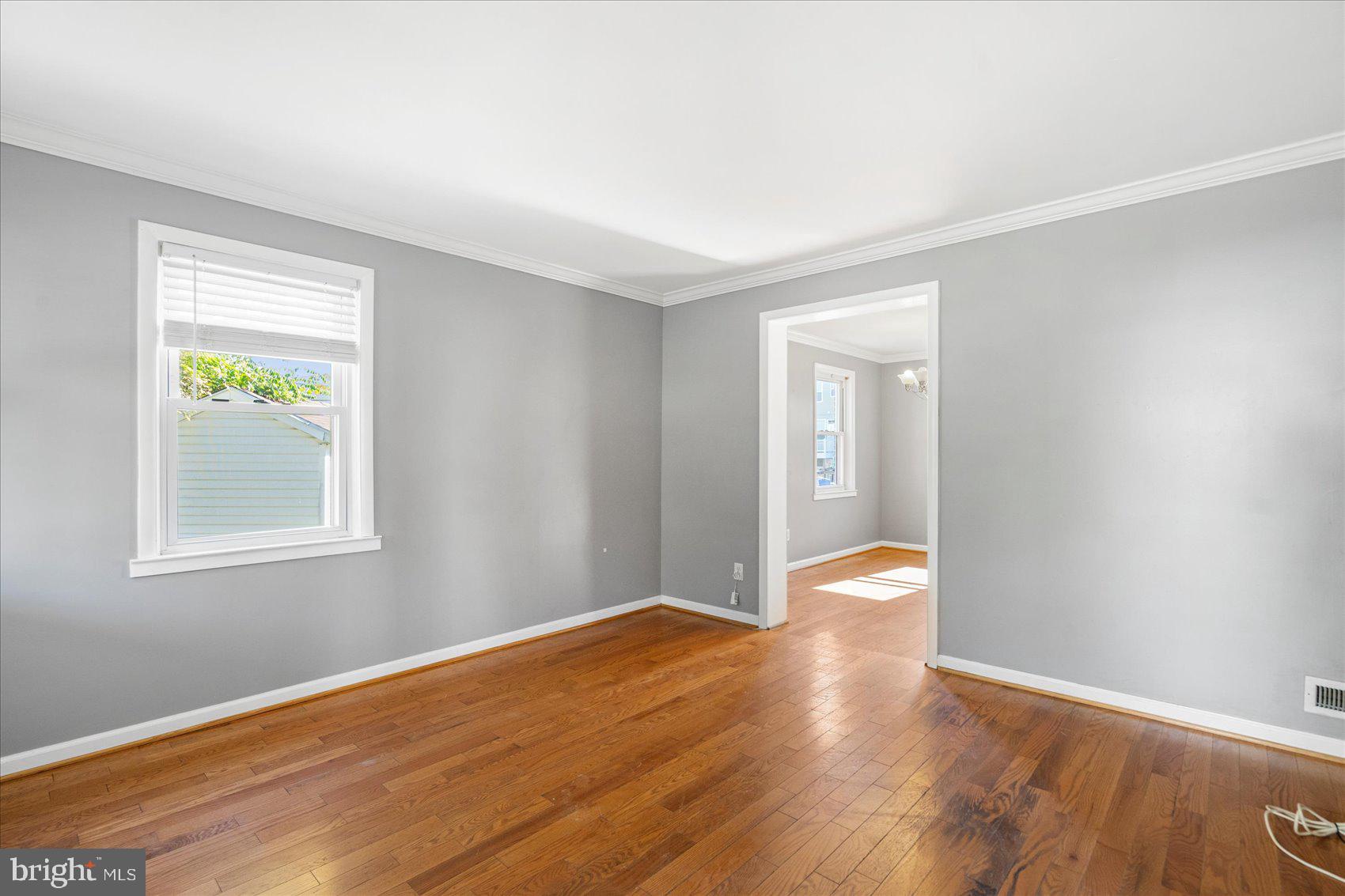 11 Cardinal Road Baltimore, MD 21221 - Photo 4 of 37 a view of an empty room with wooden floor and a window