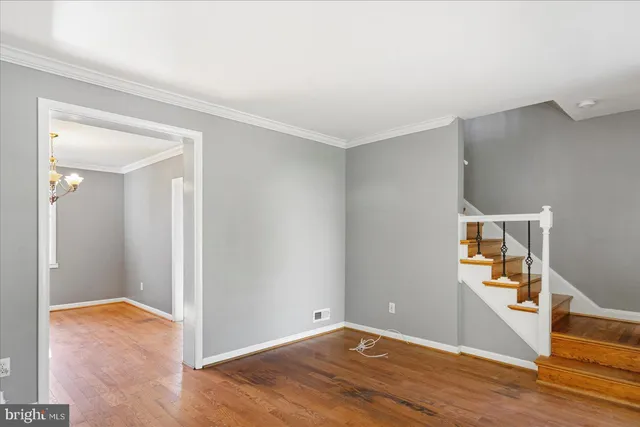 an empty room with wooden floor and entrance