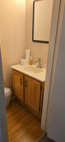 a bathroom with a granite countertop sink toilet and mirror