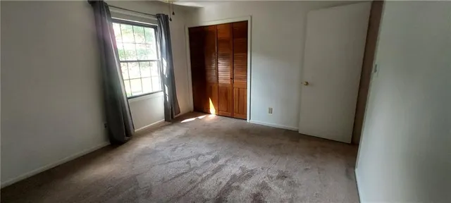 an empty room with windows and closet