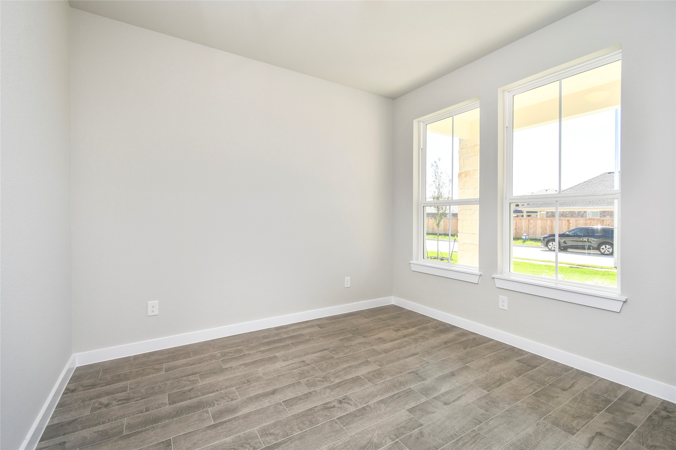 15119 Statice Trail Houston, TX 77044 - Photo 8 of 26 an empty room with wooden floor and windows